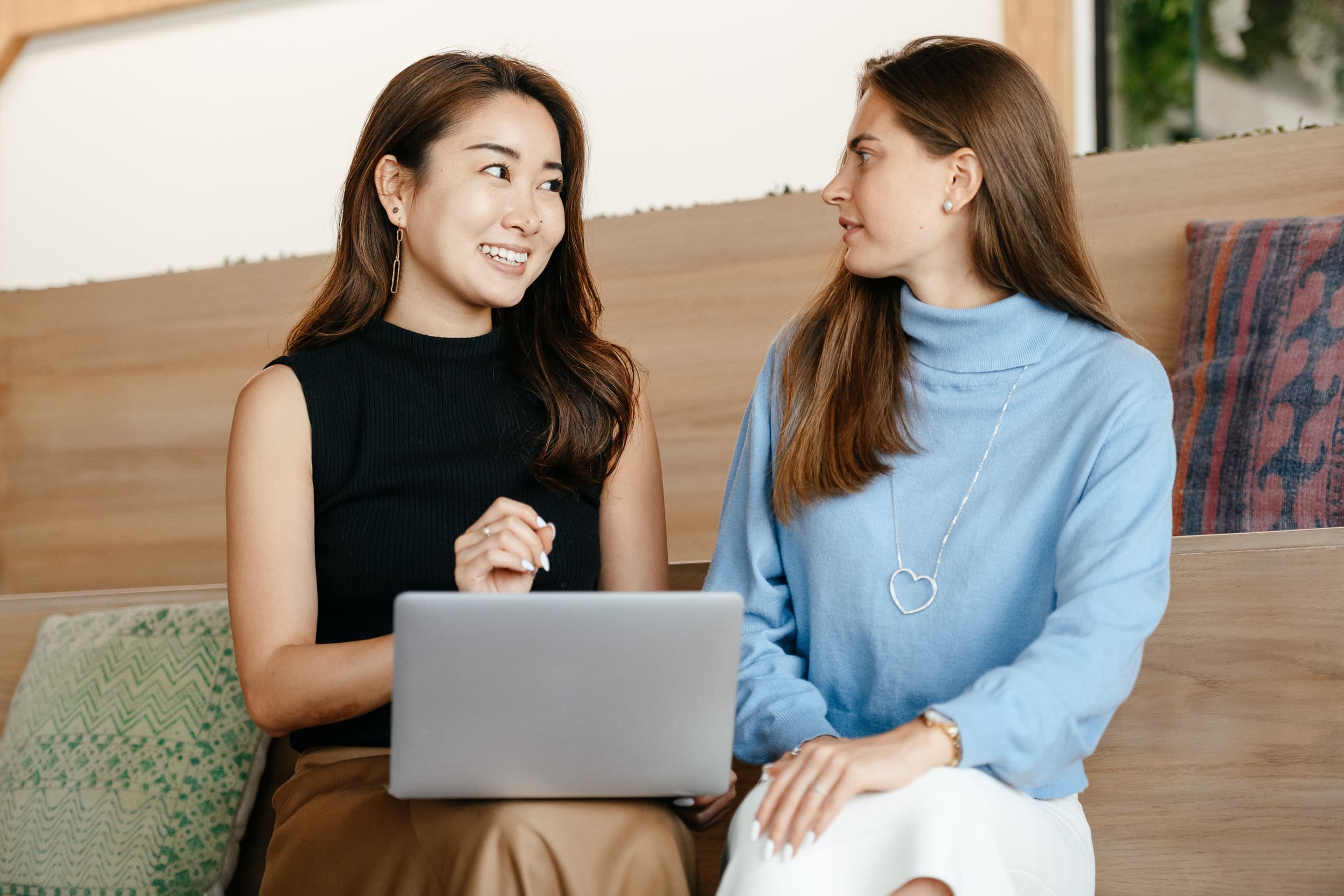 Two women talking together over a laptop